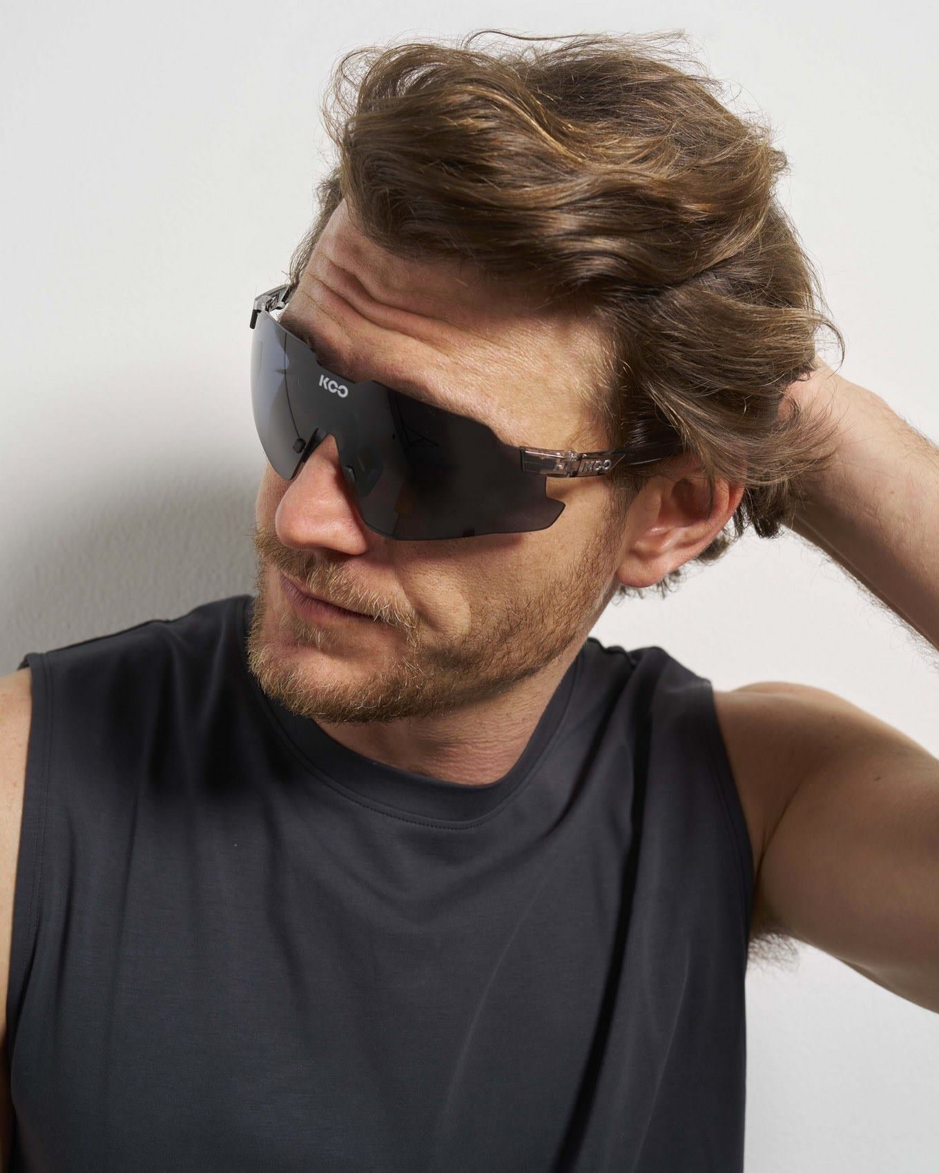 Man wearing KOO Nebula sunglasses with black glass photochromic graphite mirror lenses