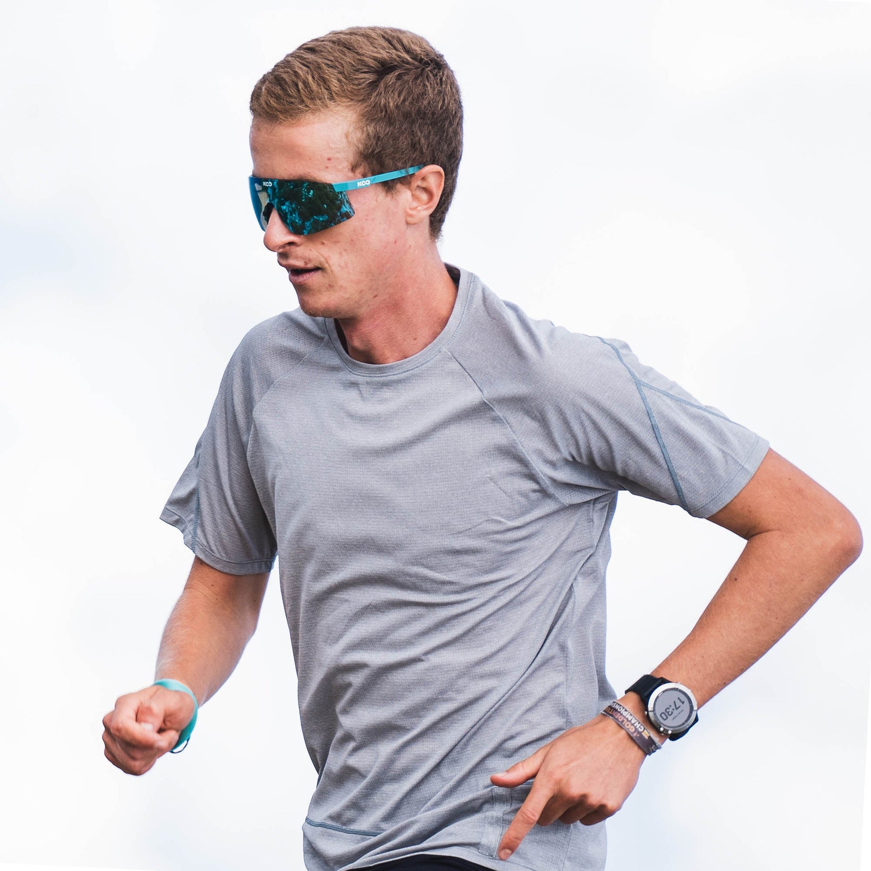 Man wearing KOO Nova sunglasses in Acqua Matt turquoise frame while running outdoors