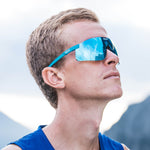 Man wearing KOO Nova sunglasses in Acqua Matt Turquoise with blue mirrored lenses looking upward