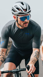 Male cyclist wearing KOO Alibi sunglasses with turquoise mirror lenses on road
