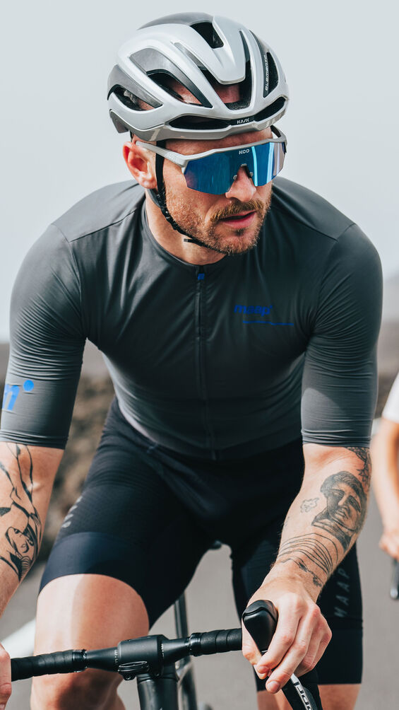 Male cyclist wearing KOO Alibi sunglasses with turquoise mirror lenses on road