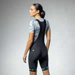 Woman wearing black ALE PRR Strada bibshorts with teal leg band details