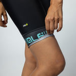 Woman wearing black ALE PRR cycling bibshorts with turquoise leg band details