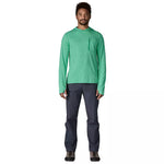 Man wearing green hooded long-sleeve shirt with chest pocket and dark pants
