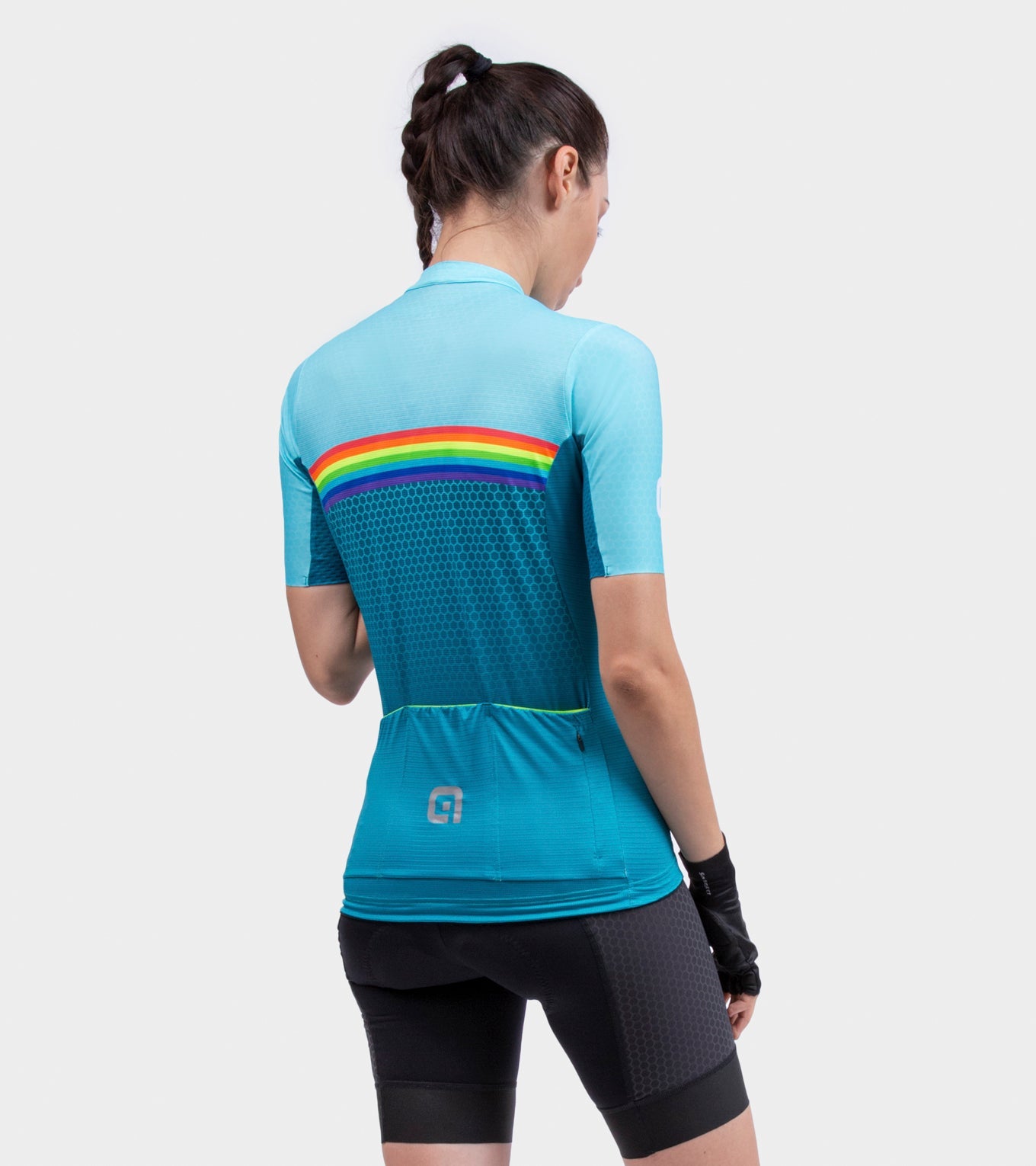 Woman wearing light blue ALE cycling jersey with rainbow stripe from behind