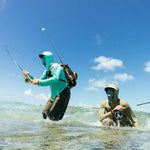 Two anglers wearing Patagonia sun hoodies while fly fishing in shallow tropical waters
