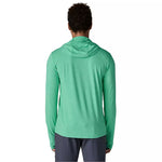 Back view of man wearing green hooded long-sleeve shirt with dark shorts