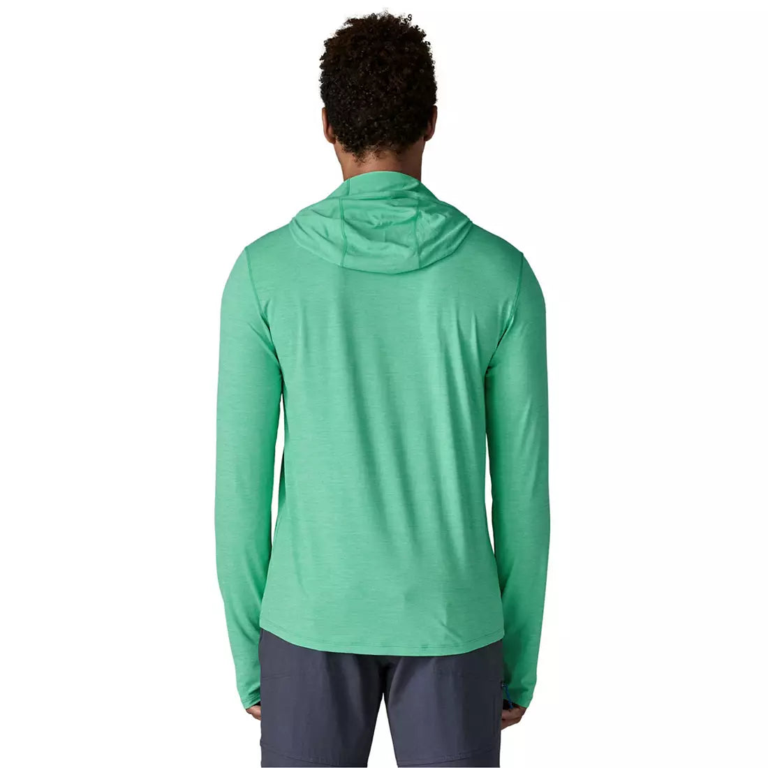 Back view of man wearing green hooded long-sleeve shirt with dark shorts