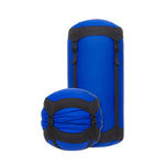 Sea To Summit blue compression sack shown compressed and uncompressed with black straps