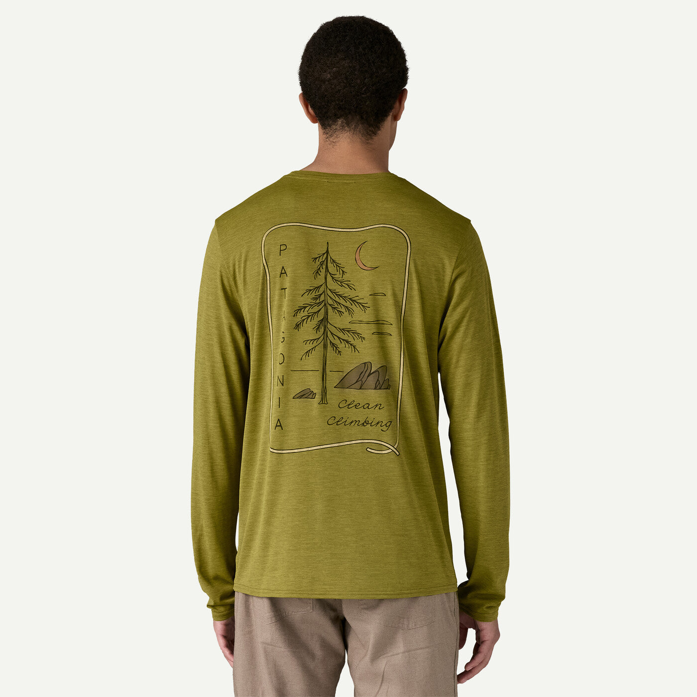 Back view of man wearing olive green Patagonia long-sleeved shirt with tree graphic