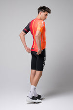 Gobik Odyssey cycling jersey in INEOS Grenadiers orange-red colorway on male model