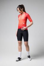 Woman wearing Gobik Carrera 2.0 short sleeve cycling jersey in cherry red with black shorts