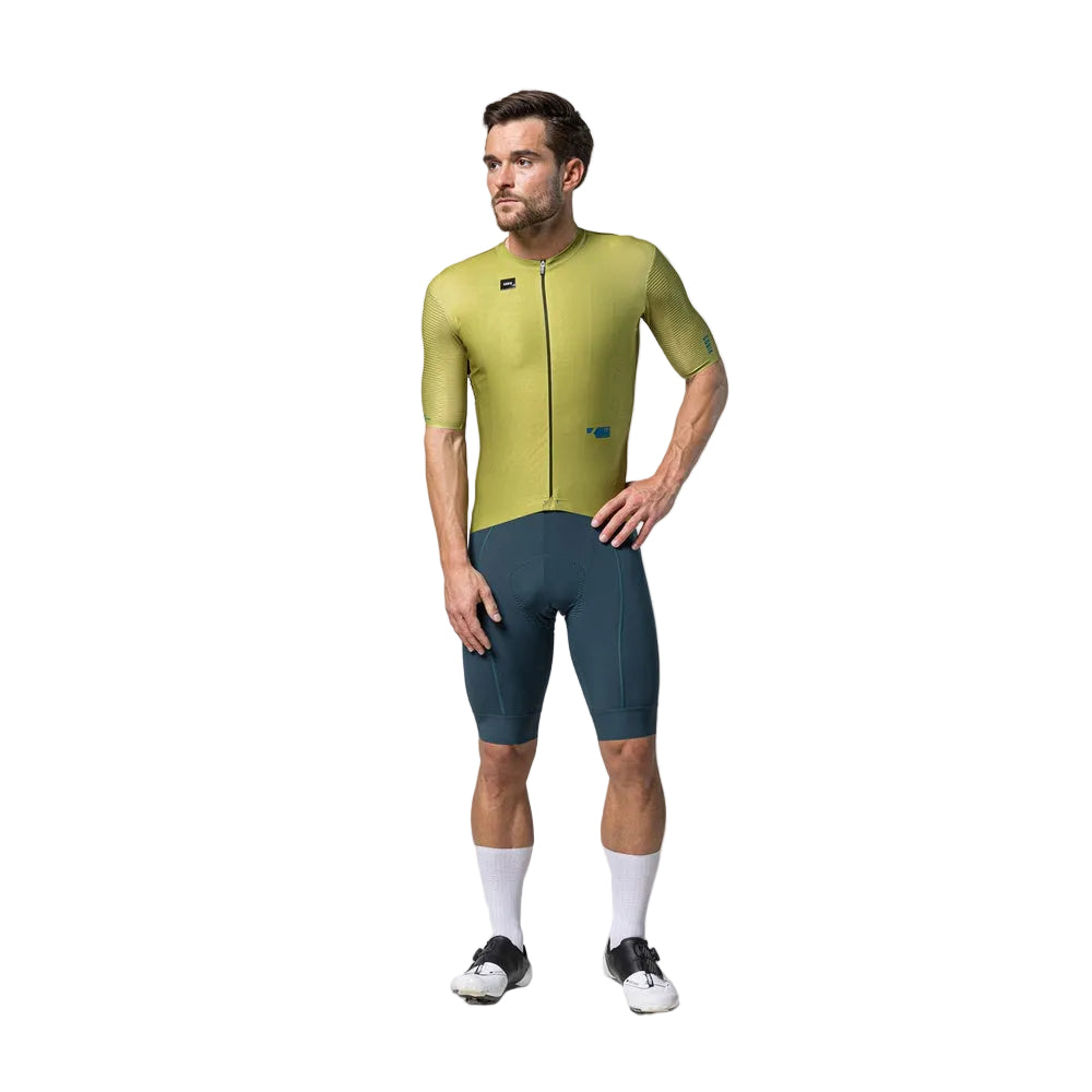 Male model wearing Gobik Magnitude cycling jersey in split green colorway with matching shorts