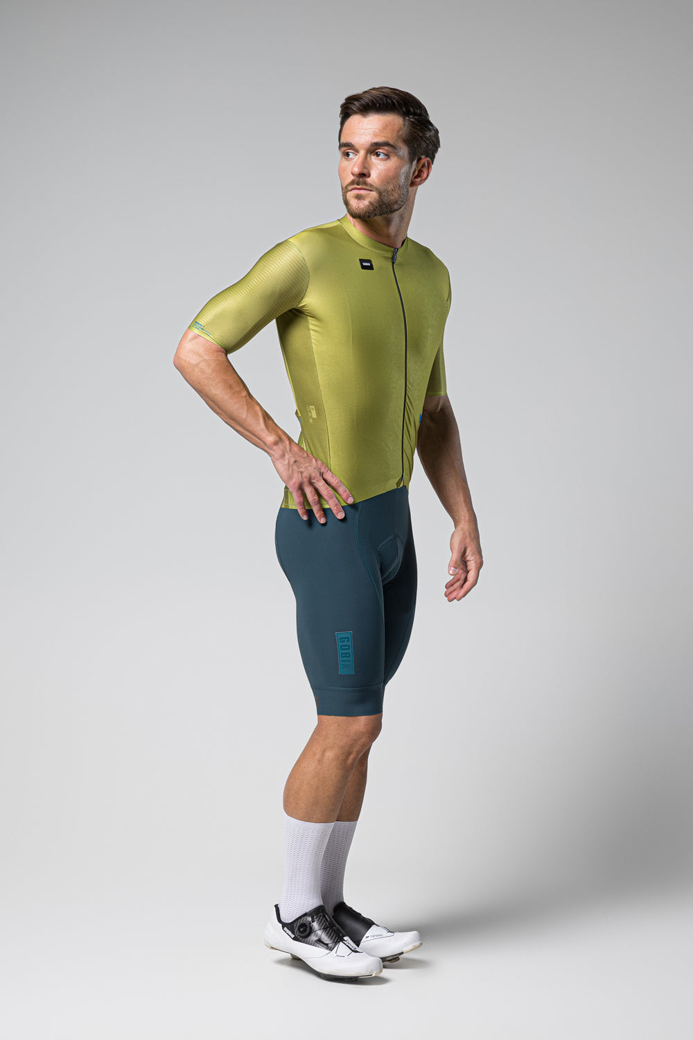 Male model wearing Gobik Magnitude cycling jersey in split green colorway with matching shorts