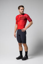 Man wearing red Gobik Stark cycling jersey with black shorts in studio