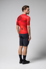 Man wearing red Gobik Stark cycling jersey with black shorts in studio photo