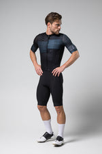 Male cyclist wearing black Gobik Stark short sleeve jersey with navy gradient panel