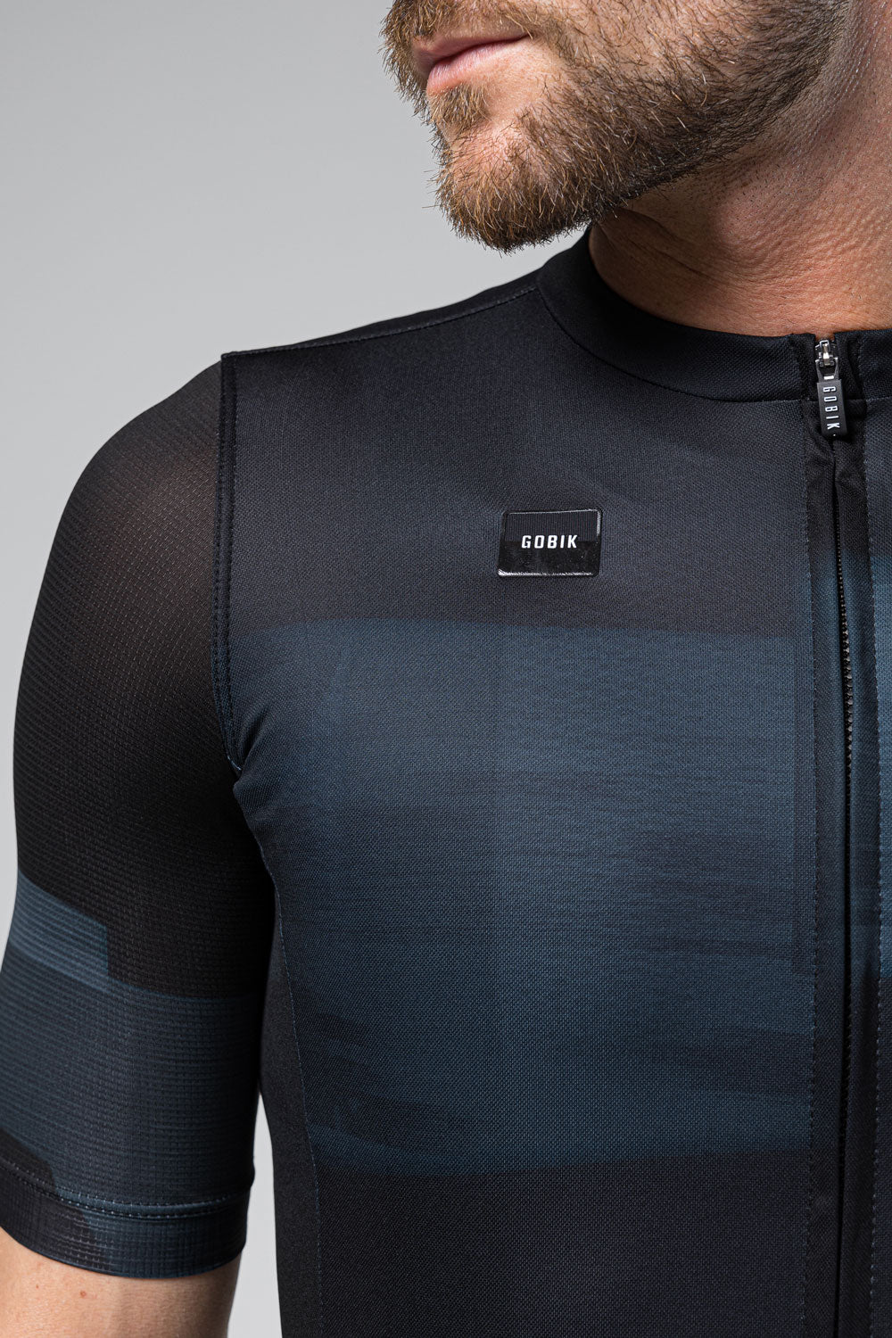 Man wearing Gobik Stark short sleeve cycling jersey in moonless dark navy colorway