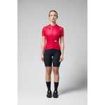 Woman wearing bright pink Gobik Stark cycling jersey with black shorts