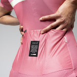 Woman wearing pink Gobik cycling jersey and shorts in studio setting