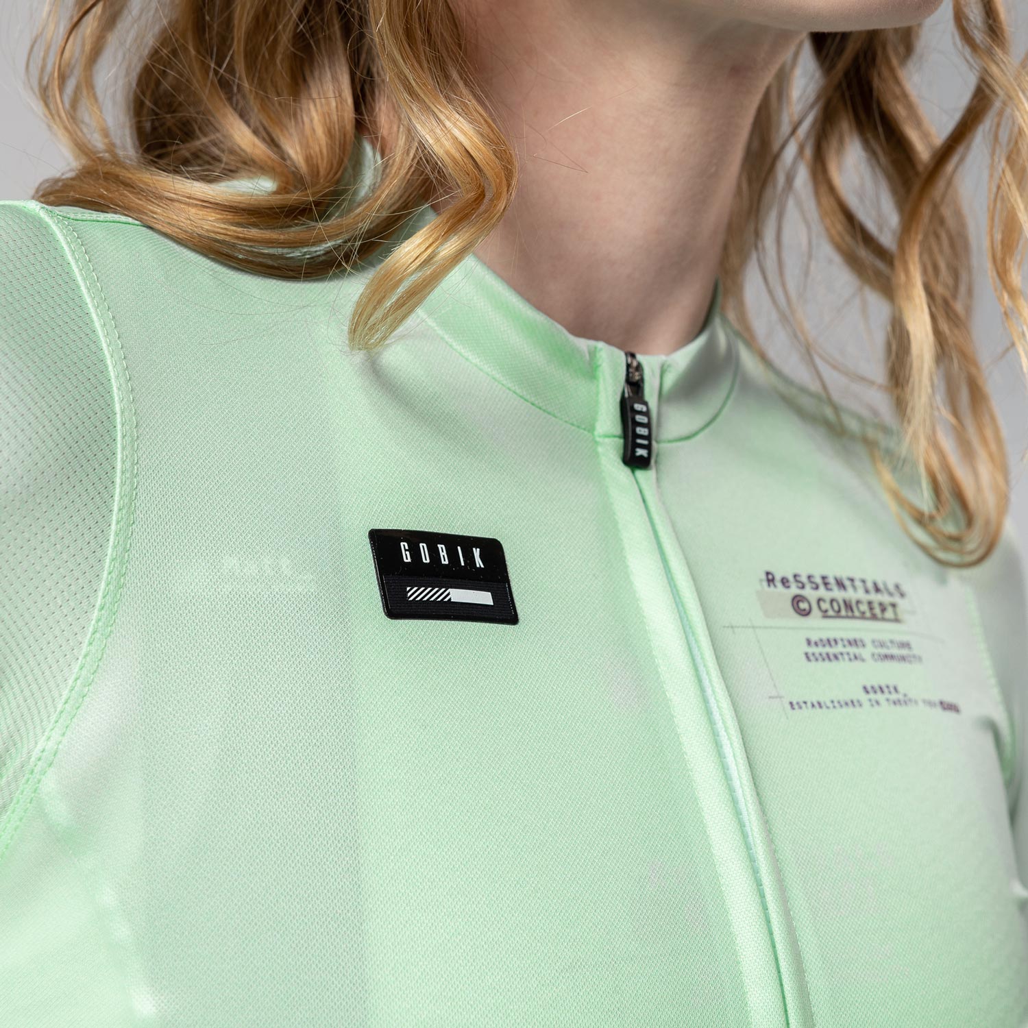 Woman wearing Gobik Stark light mint green cycling jersey with black logo patches