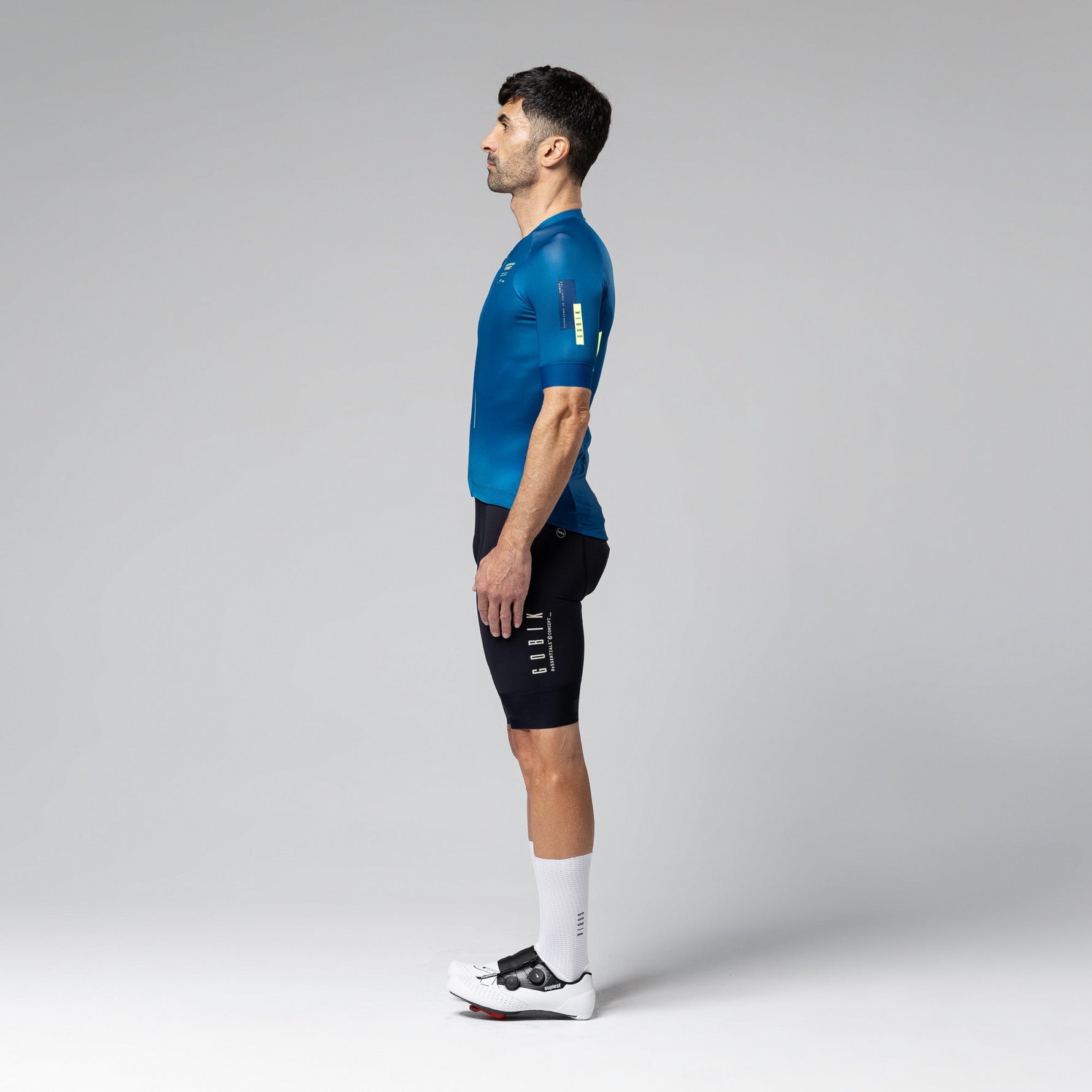 Man wearing Gobik CX 2.0 Pro blue cycling jersey and black shorts in studio