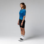 Woman wearing blue Gobik CX 2.0 Pro cycling jersey with black shorts