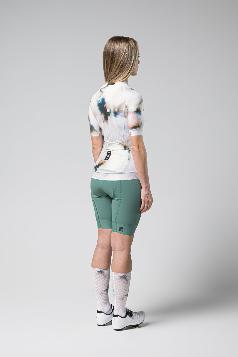 Woman wearing Gobik CX Pro cycling jersey with tie-dye pattern and green shorts