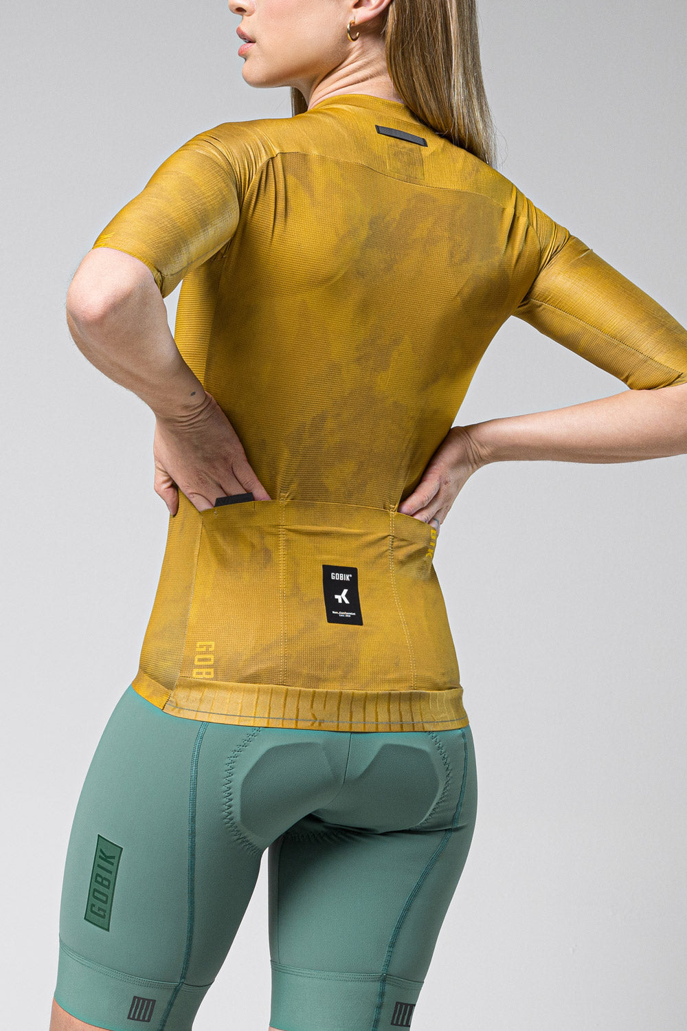 Woman wearing Gobik Infinity short sleeve cycling jersey in ginger yellow color