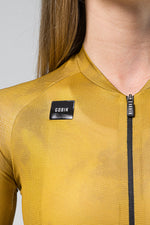 Close-up of GOBIK cycling jersey in golden yellow showing brand label and zipper detail