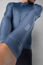 Man wearing blue Gobik CX Pro long sleeve cycling jersey in dynamic pose