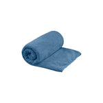 Sea To Summit Tek Towel in blue, partially rolled up against white background