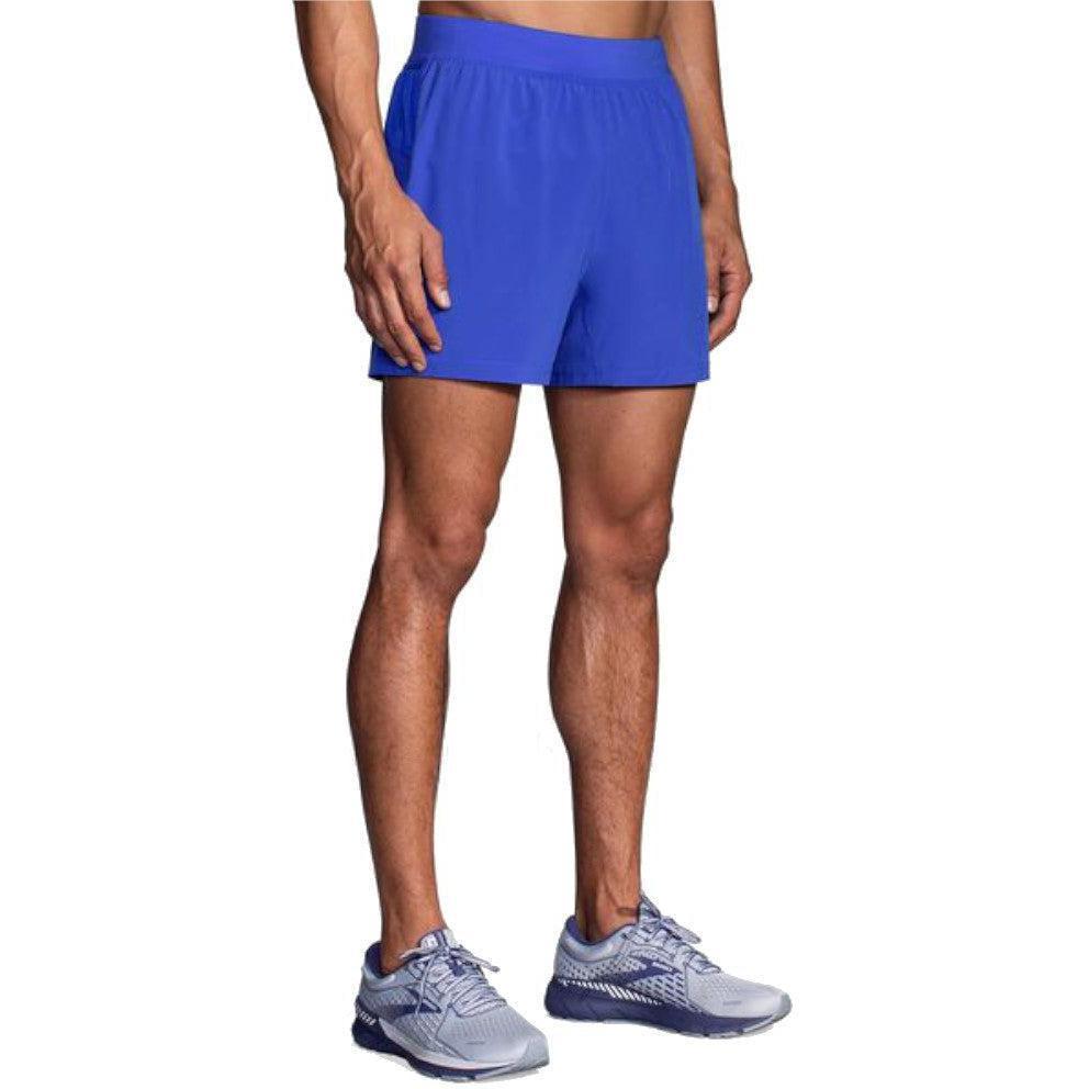 Brooks Sherpa 5-inch running shorts in Amparo Blue worn by male model with gray Brooks sneakers