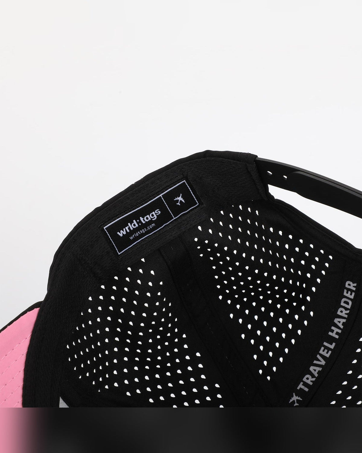 Close-up interior detail of Wrld Tags Miami hat showing brand label, pink lining and perforated fabric