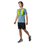 Man wearing Nathan QuickStart 2.0 hydration vest in lime green over blue running shirt