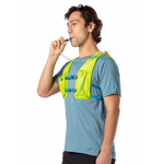 Man wearing Nathan QuickStart hydration vest in lime green, drinking from tube