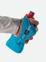 Hand holding Nathan Quick Squeeze handheld water bottle with mesh grip in turquoise blue
