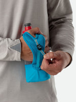 Person holding Nathan Quick Squeeze handheld water bottle with blue mesh grip and strap