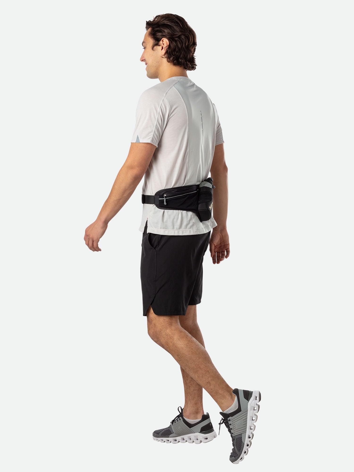 Man running wearing Nathan Peak Hydration Waist Pack in black with gold accents