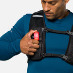 Man wearing vest demonstrating red Nathan LED safety light clip attachment
