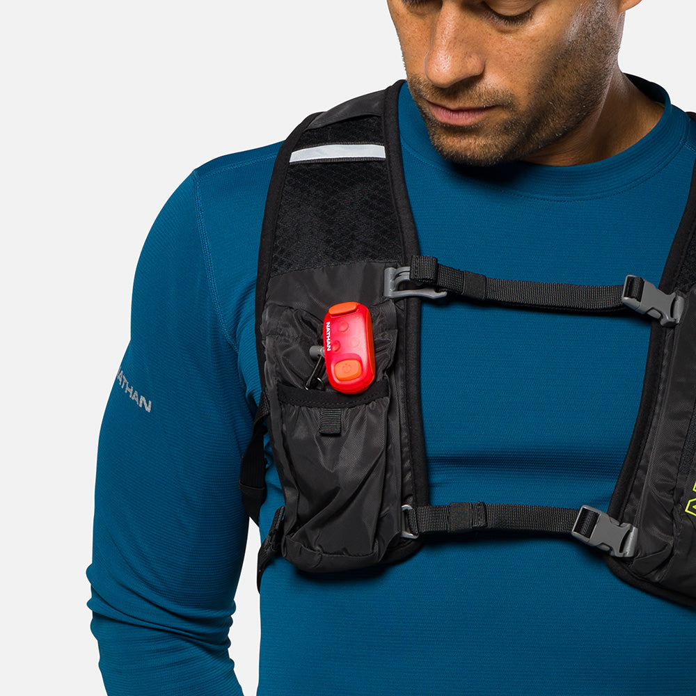 Nathan red LED safety light clipped to black running vest chest strap