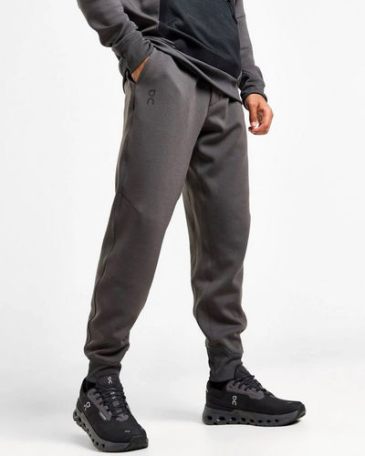 Man wearing On brand dark gray sweat pants with matching hoodie and black sneakers
