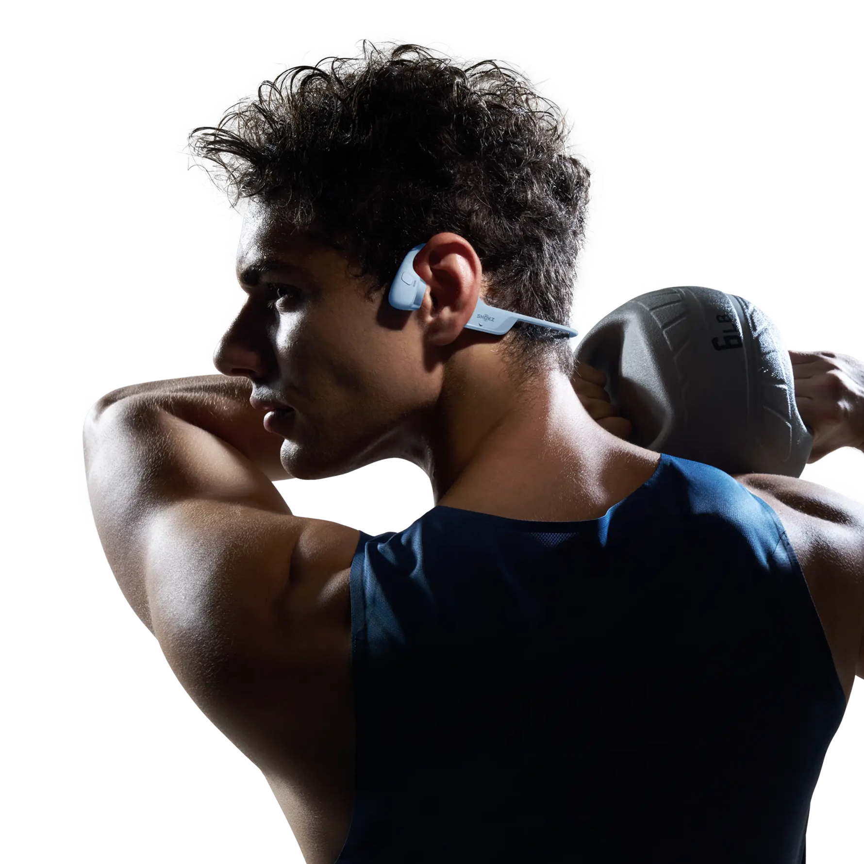 Athletic man wearing Shokz bone conduction headphones while exercising in tank top