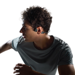 Man wearing Shokz bone conduction headphones while running in athletic shirt