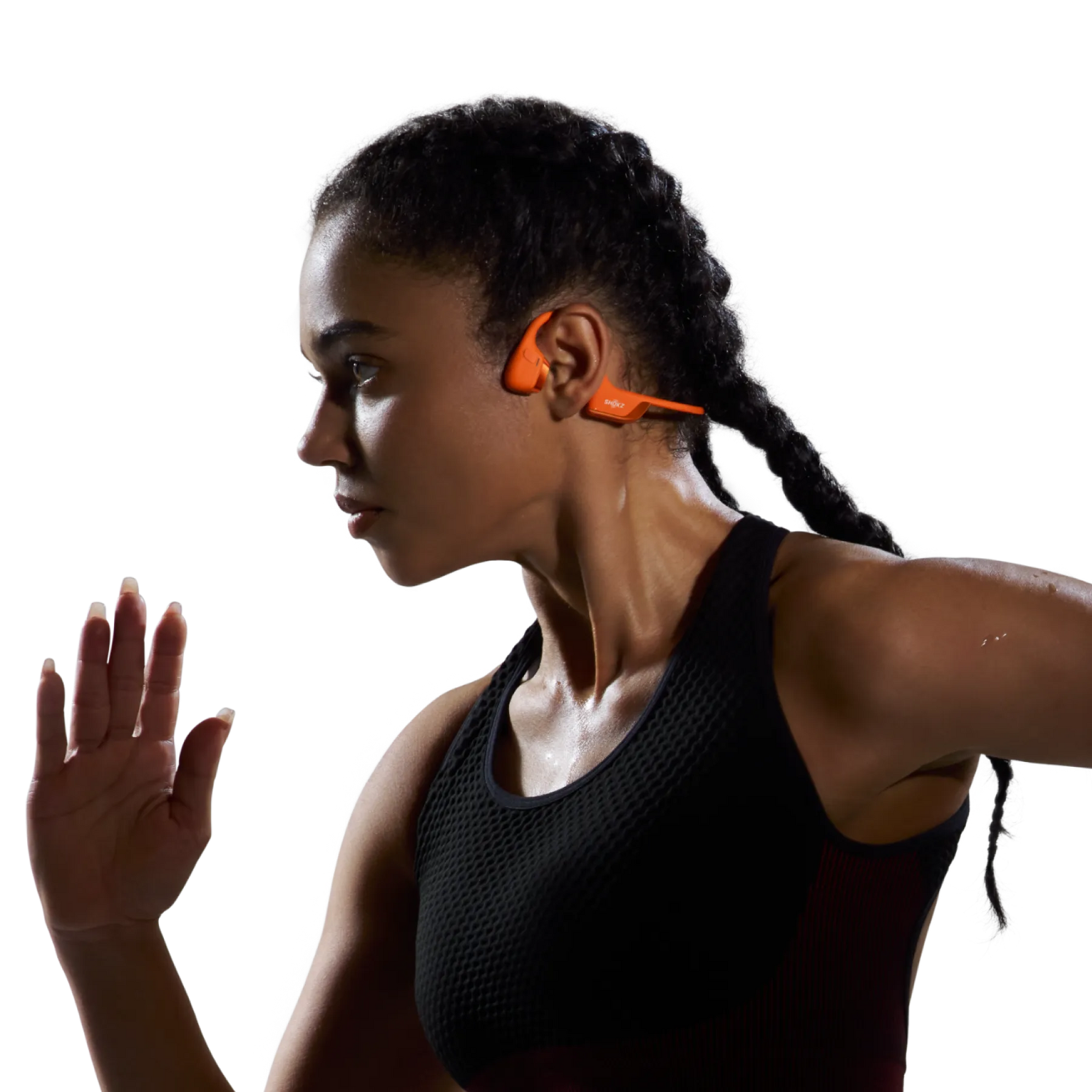 Woman wearing orange Shokz OpenRun Pro 2 bone conduction headphones during workout