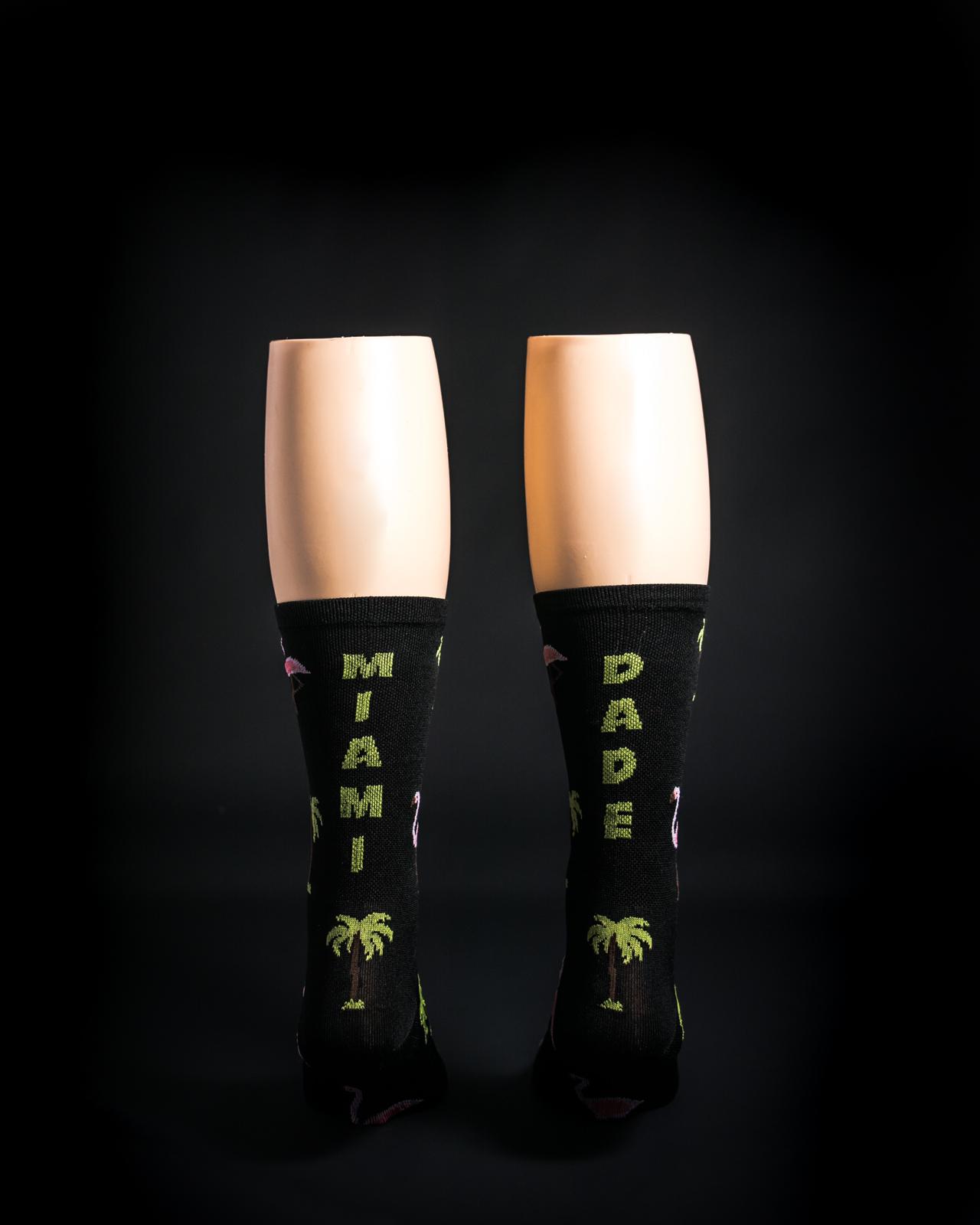 Black crew socks with green Miami Dade text and palm tree pattern
