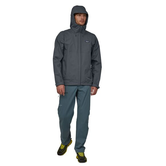 Man wearing Patagonia Men's Torrentshell 3L Jacket in Buckhorn Green with matching pants