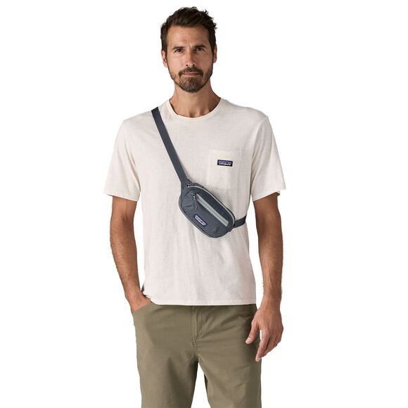 Man wearing dark blue Patagonia Terravia Mini Hip Pack crossbody style