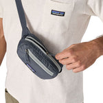 Person wearing Patagonia Terravia Mini Hip Pack in Smolder Blue across chest