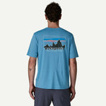 Back view of man wearing light blue Patagonia t-shirt with mountain graphic